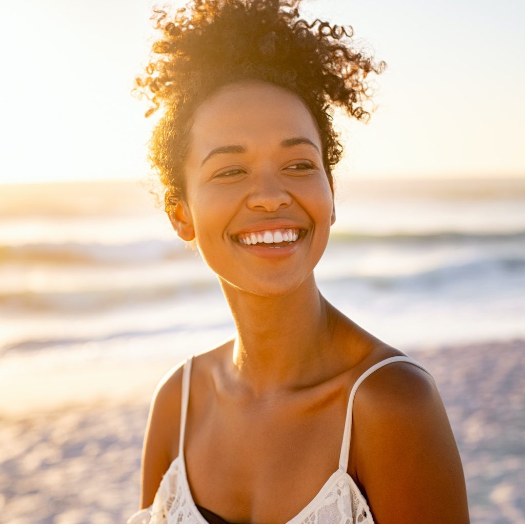 dentist boca raton African young woman relaxing at beach during sunset Sedation Dentistry