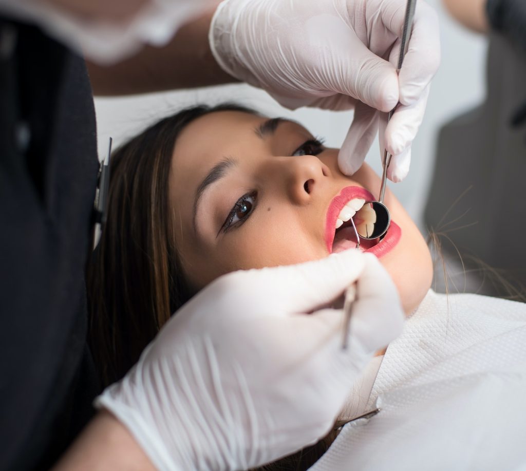 Close up of beautiful young woman having dental check up in dental clinic Emergency Dentistry