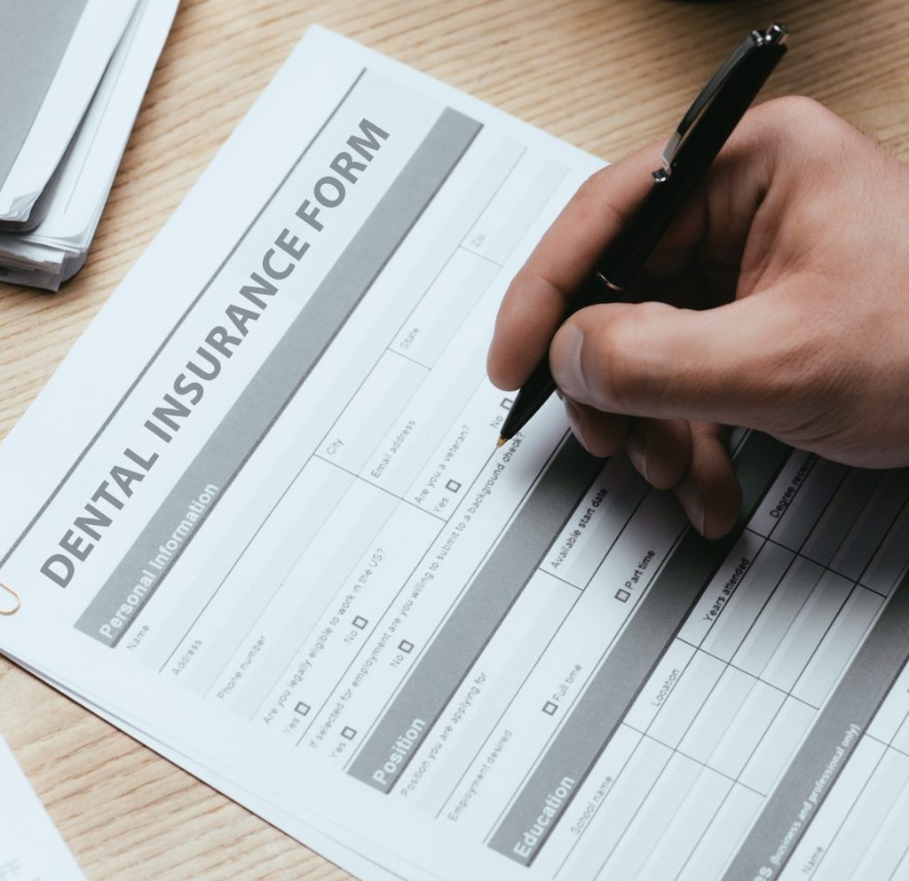 cropped view of man filling in Dental Insurance Form Dentist Concept