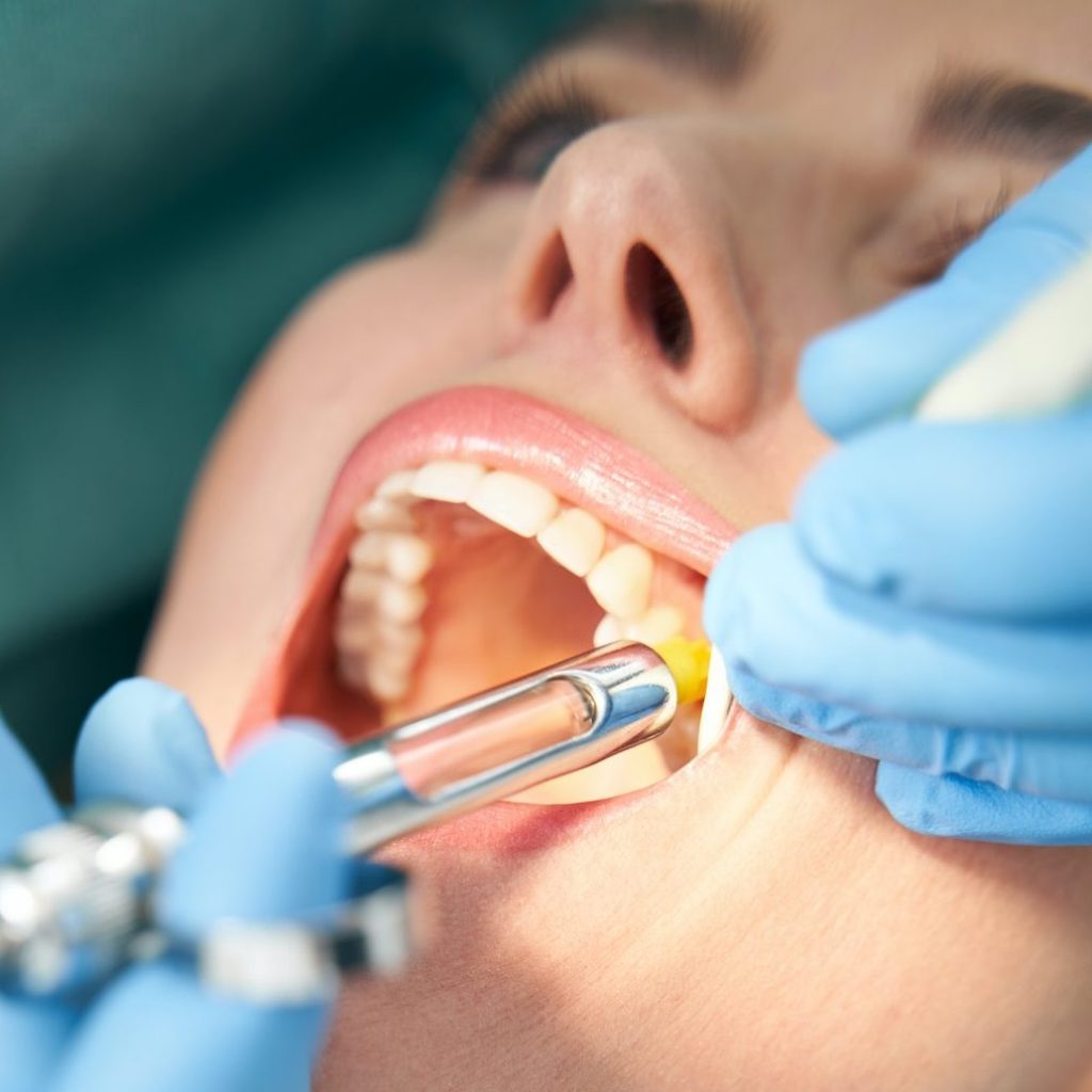 Dentist injecting anesthetic medicine into patient inner cheek