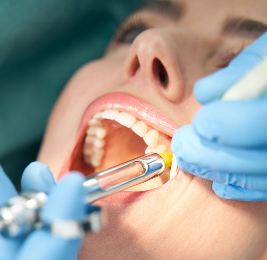 Dentist injecting anesthetic medicine into patient inner cheek