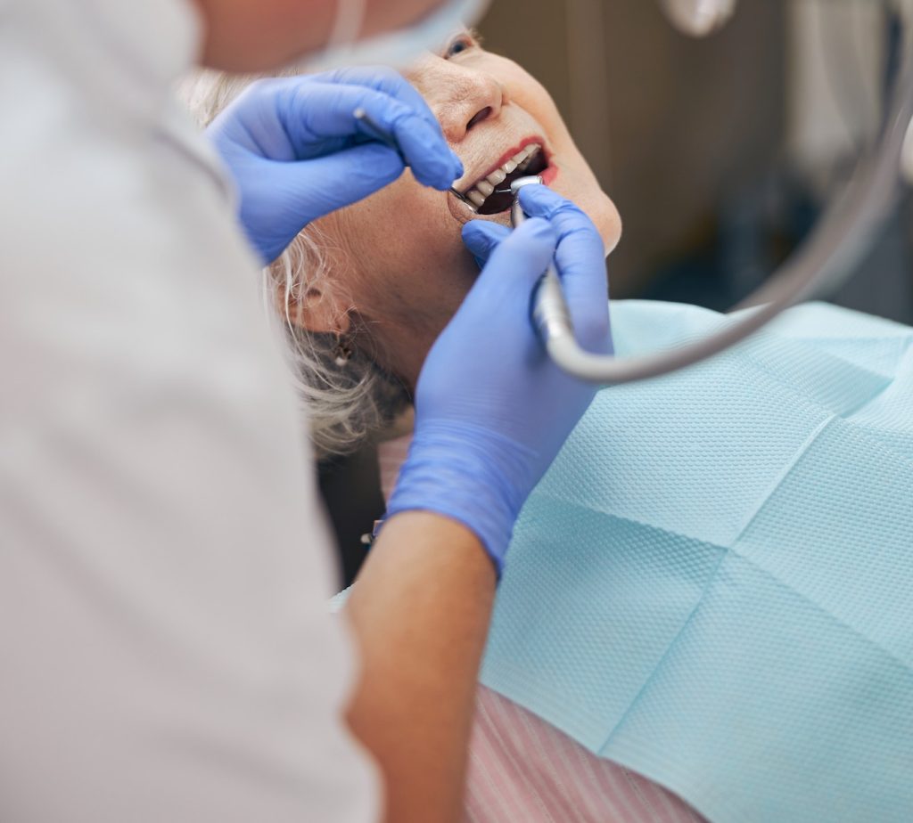 Male dentist working with dentist drill on patient