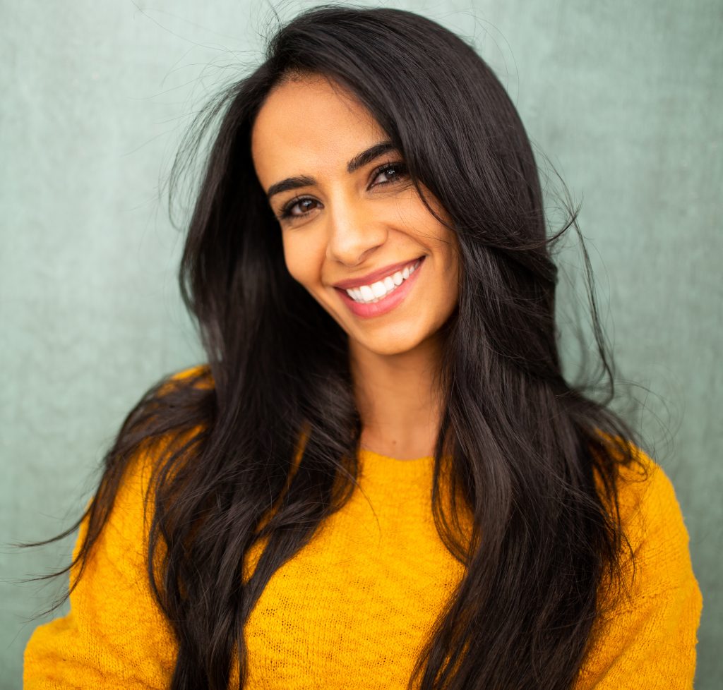 Beautiful hispanic woman smiling against green background Cosmetic Dentistry